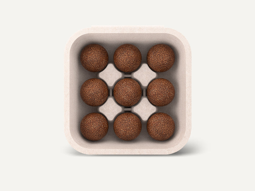 Eine offene CoffeeB Verpackung von oben mit 9 Coffeeballs darin.