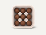 Eine offene CoffeeB Verpackung von oben mit 9 Coffeeballs darin.